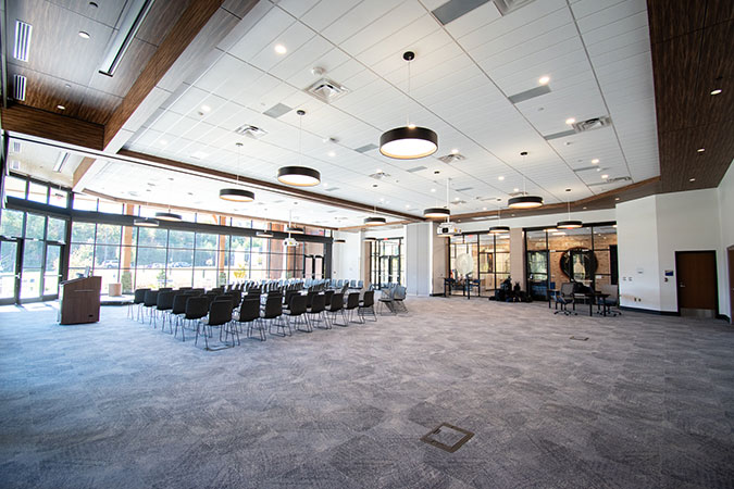ralston hall rows of chairs and a podium with gigantic windows