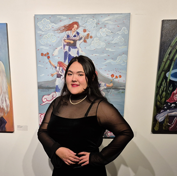 Julie Kral in front of her paintings