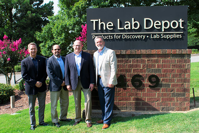 four men standing in front of The Lab Depot sign