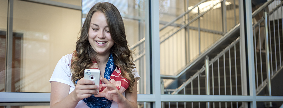 Female student using smartphone. Goes to information on paying tuition and fees.