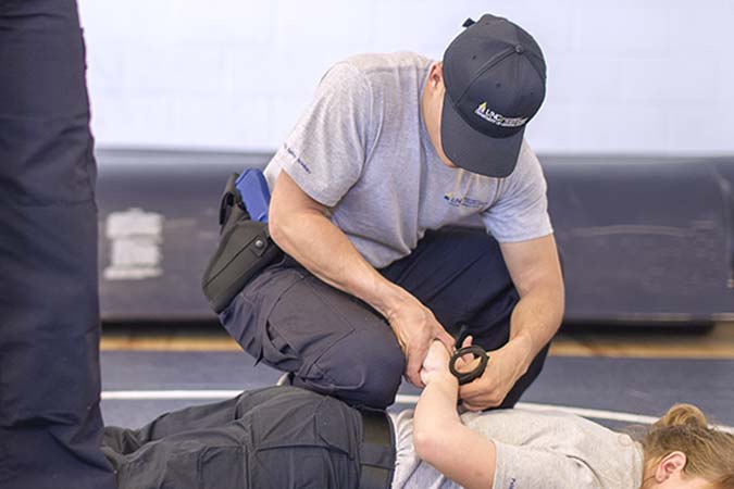 student practicing handcuffing