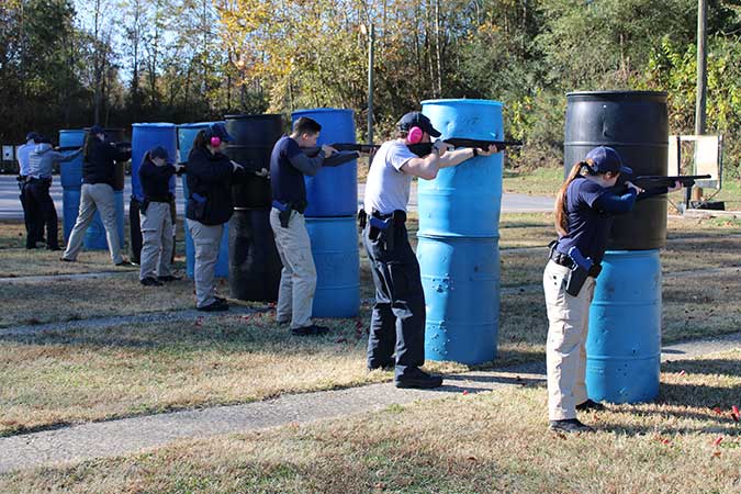 Students holding gun on firing range