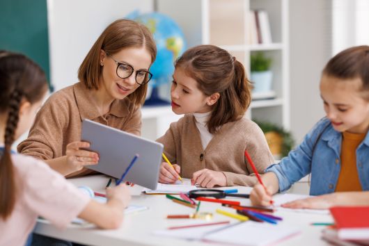 Teacher and young students studying