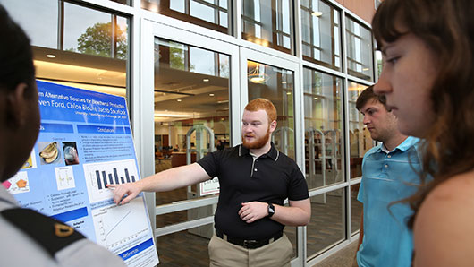 student presenting research poster