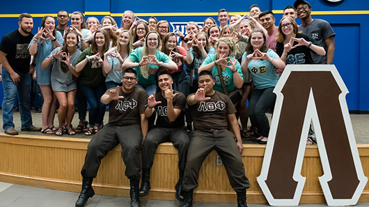 a newly formed fraternity pose for a photo 