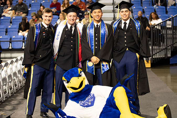 guys posing with Nigel at graduation