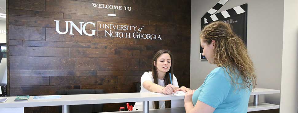 employee assisting someone at information desk