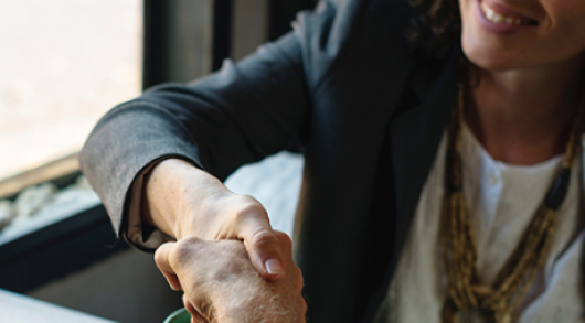 Two hands shaking over coffee