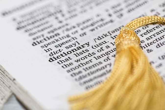 Definition of the word definition with tassel laying across the page.