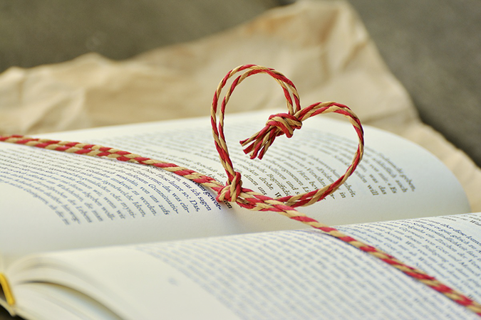 Book wrapped with string heart. Go to Donate to the Libraries.