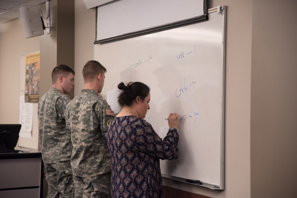 Students use Arabic characters to write on whiteboard