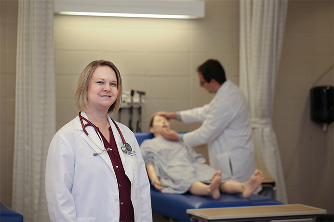 nursing student posing in front of mannequin in back