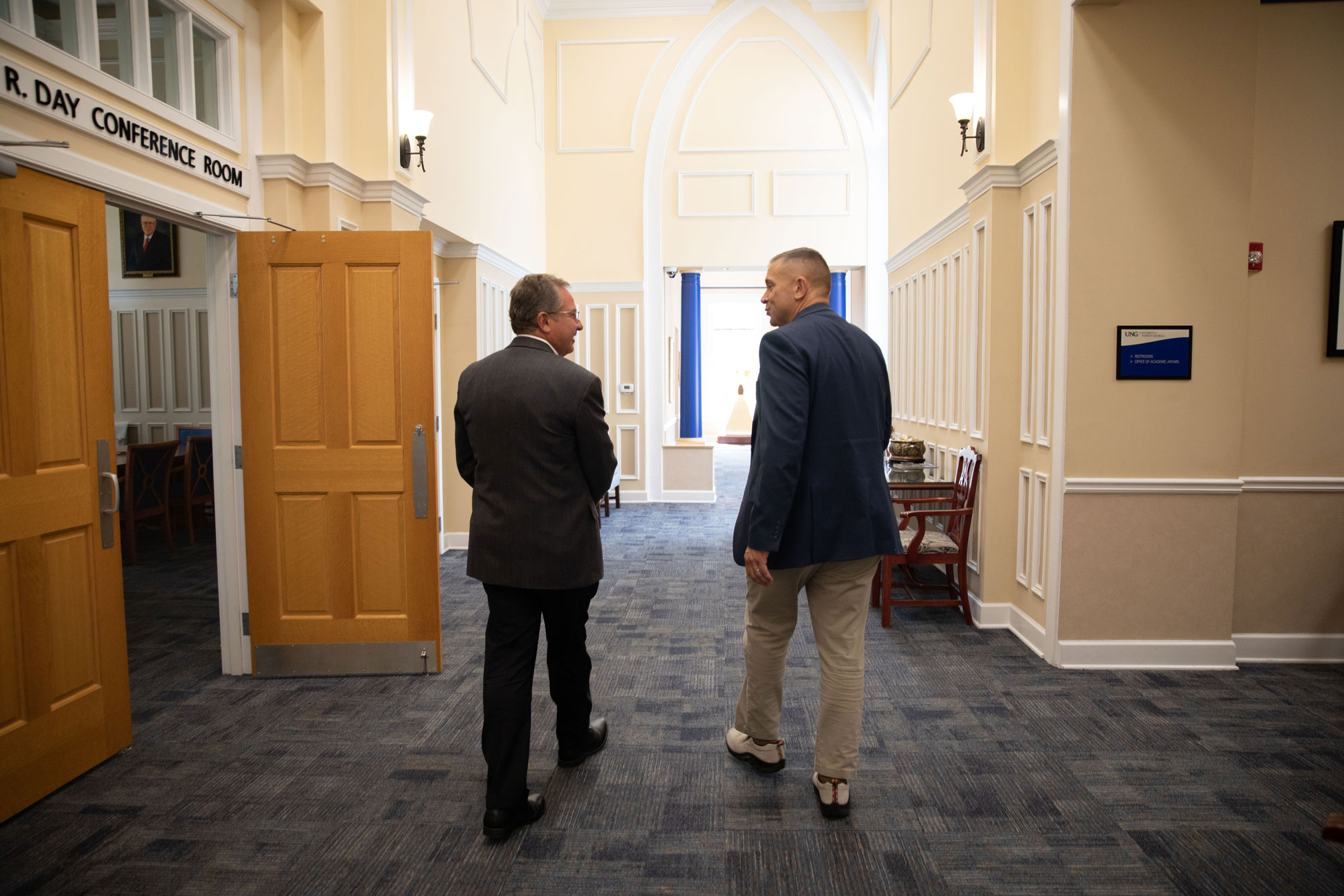 President Shannon with Advancement talking in the hallways of Price Memorial