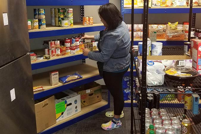 woman stocking canned goods in pantry