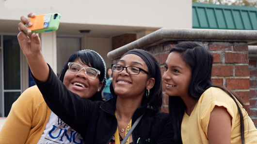 3 female students taking a smiling selfie
