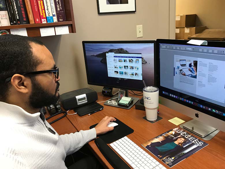 Derek working on magazine layout on computer